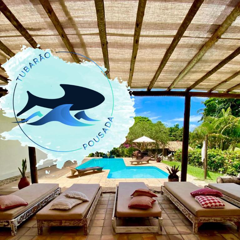 a pool with two mattresses and a sign for a resort at Pousada Tubarão in Arraial d'Ajuda