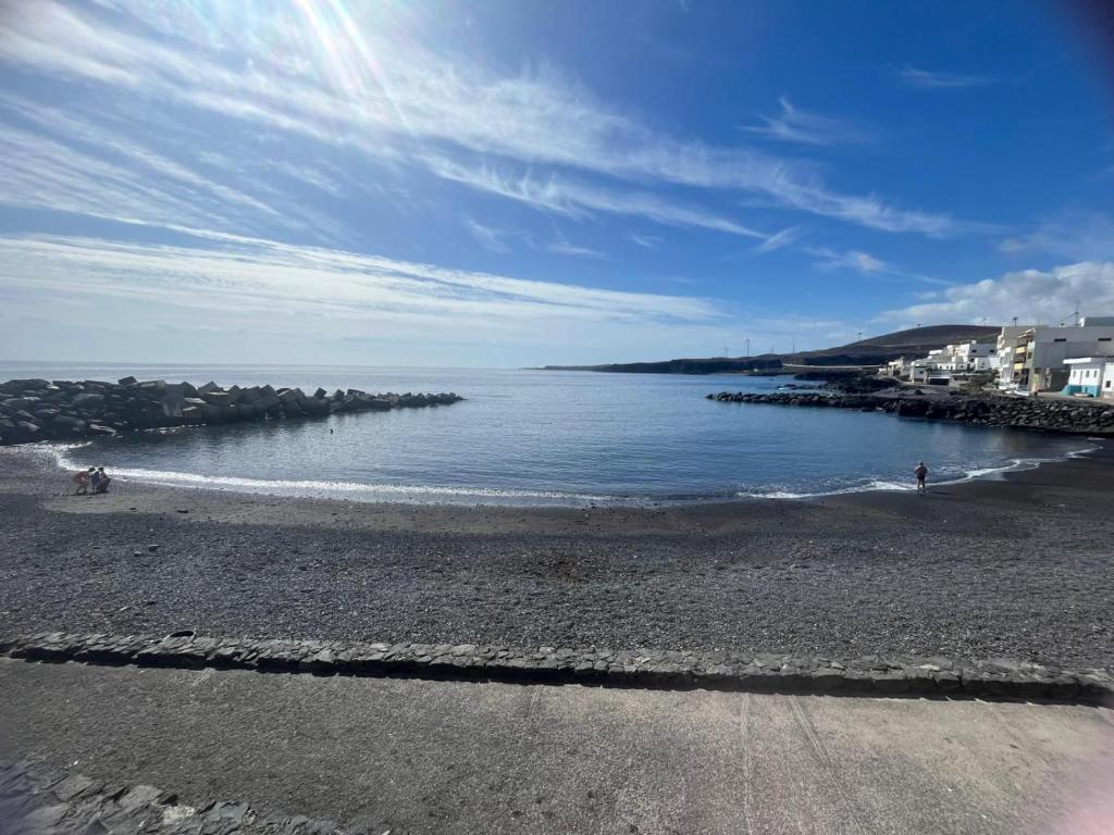 a beach with a body of water and buildings at Orion's Moon in Las Eras