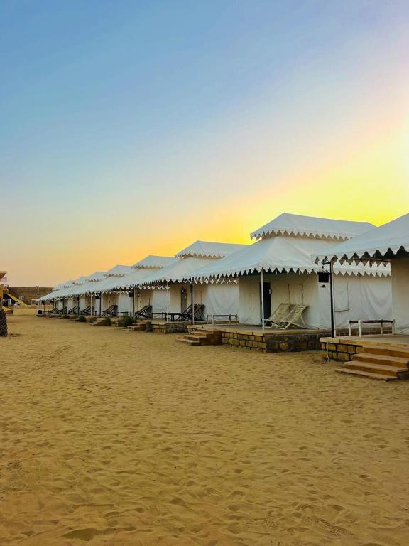 a row of white buildings on the beach at HP Desert Luxury Camp in Jaisalmer