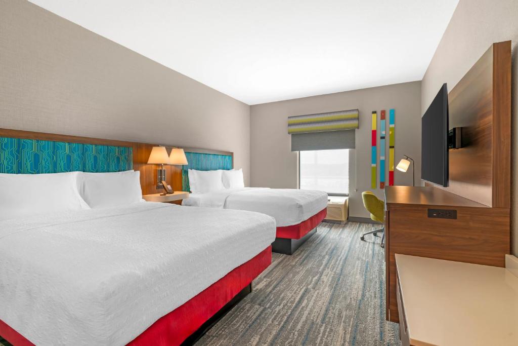 een hotelkamer met twee bedden en een flatscreen-tv bij Hampton Inn Junction City in Junction City
