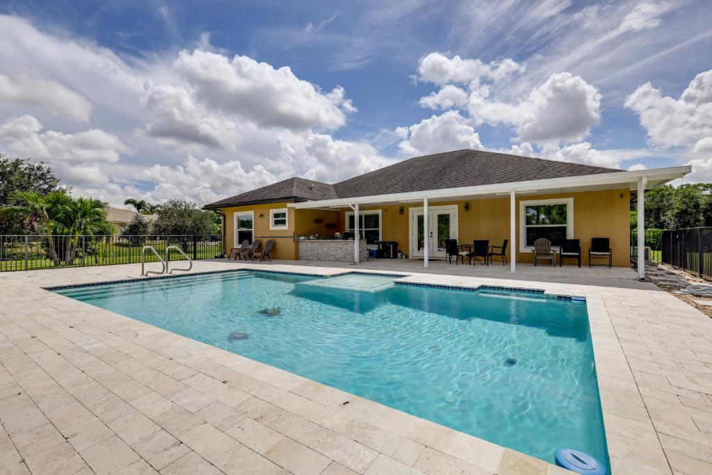 ein Swimmingpool vor einem Haus in der Unterkunft Outdoor Kitchen and Patio Loxahatchee Oasis! in Royal Palm Beach