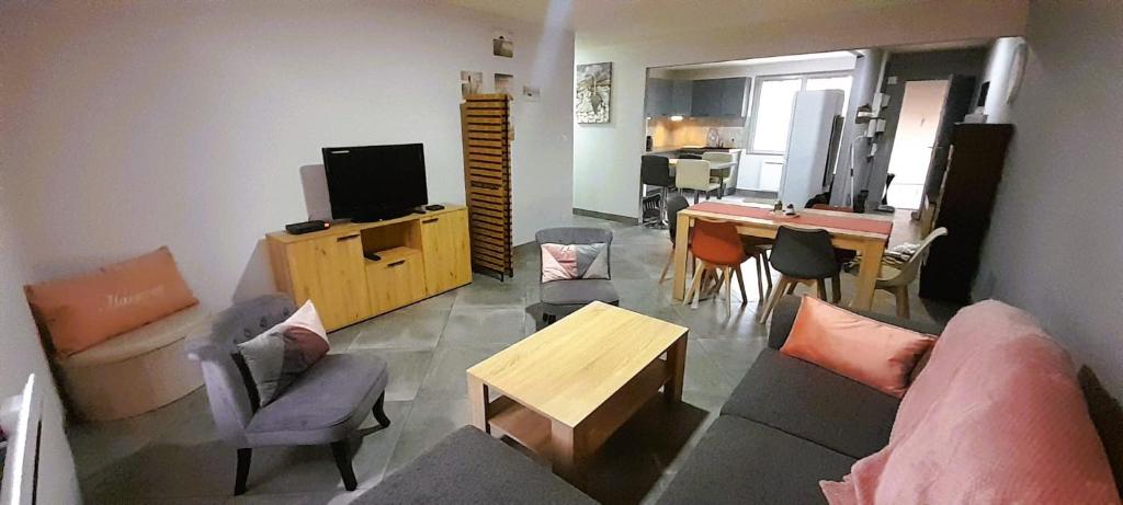 a living room with a couch and a table at Le St Roch - appart 6-8 pers - wifi - centre ville in Issoudun