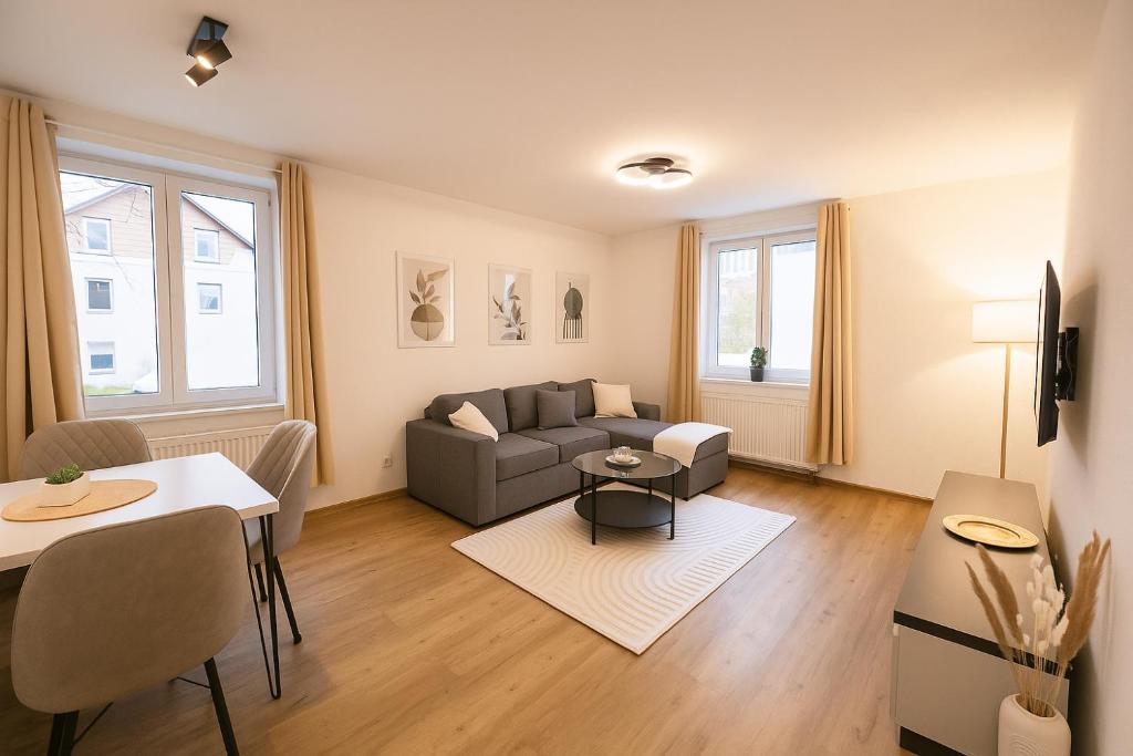 een woonkamer met een bank en een tafel bij Allgäu Suites - Innenstadt, Schlafzimmer, Küche, Parkplatz möglich, Dachterrasse in Kempten