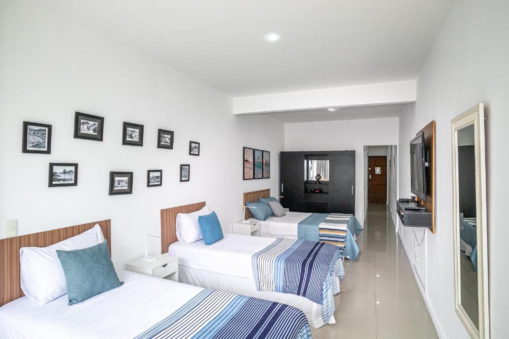 ein Hotelzimmer mit zwei Betten und einem Flachbildfernseher in der Unterkunft Studio Solar de Copacabana Vista Mar in Rio de Janeiro
