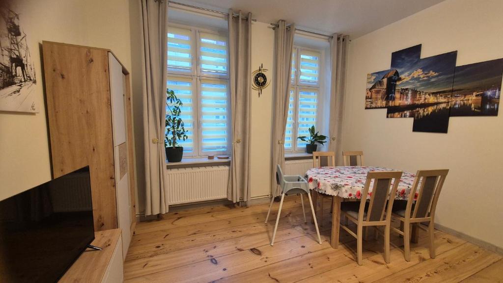 een eetkamer met een tafel en stoelen en een raam bij Sarantis Apartment in Old Town Gdansk in Gdańsk