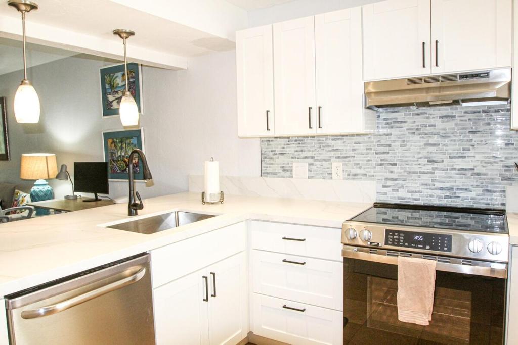 a kitchen with white cabinets and a sink at 2b2b AC Magic Tides Kona near Magic Sands Beach in Kailua-Kona