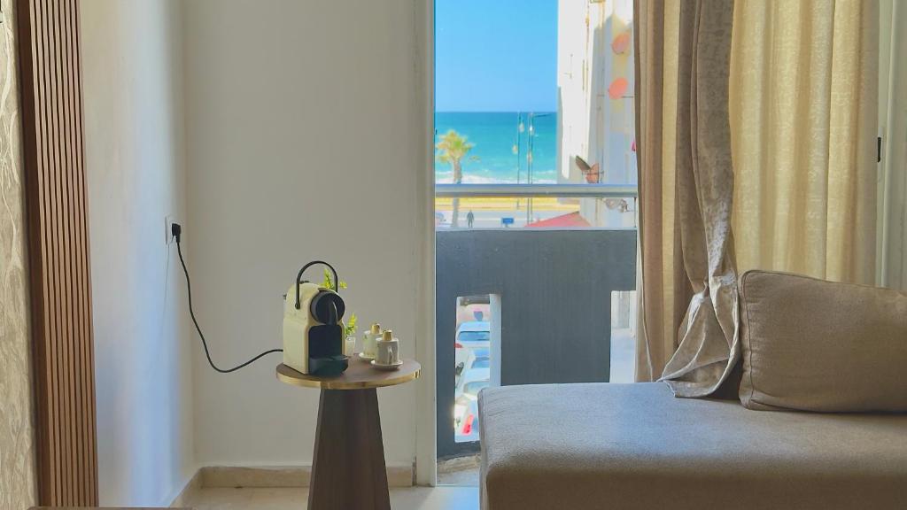 Habitación con sofá y vistas al océano. en Super appart vue sur mer, en Rabat