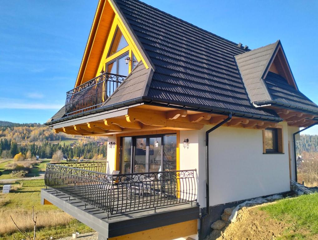 a house on a hill with a balcony at Siedem Światów Domek in Jurgów