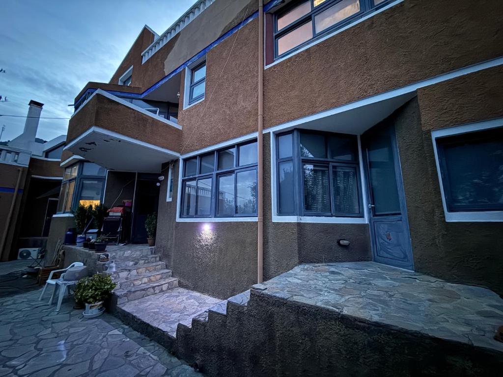 a brick building with a staircase leading to the front door at Blue Note in Mytilini