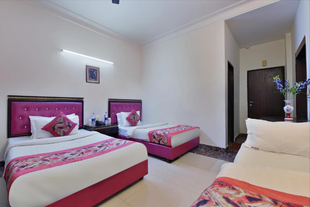 a hotel room with two beds and a couch at Hotel Blue Star - Paharganj Delhi in New Delhi