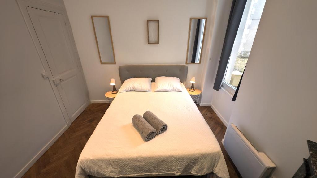 zwei Betten in einem kleinen Zimmer mit zwei Hausschuhen in der Unterkunft Le Nid Auxerrois in Auxerre