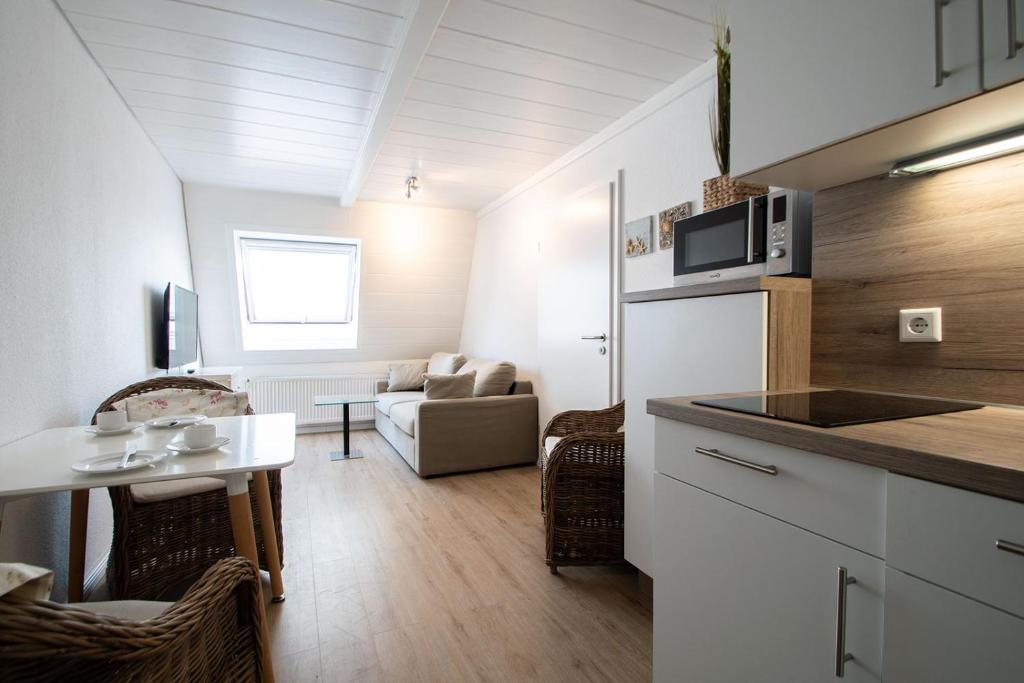 a small kitchen and living room with a couch at Kaffeehaus - Fewo 3 in Norderney