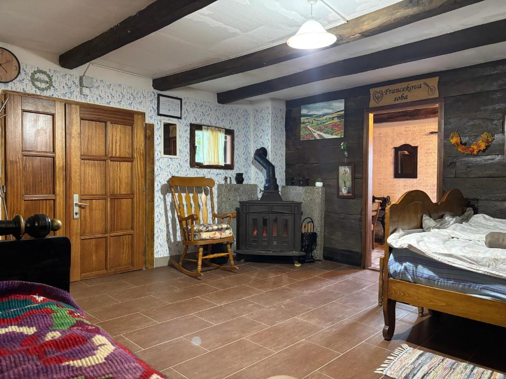 een kamer met een open haard en een bed en een slaapkamer bij Hiža Bake Veronike in Hrašćina