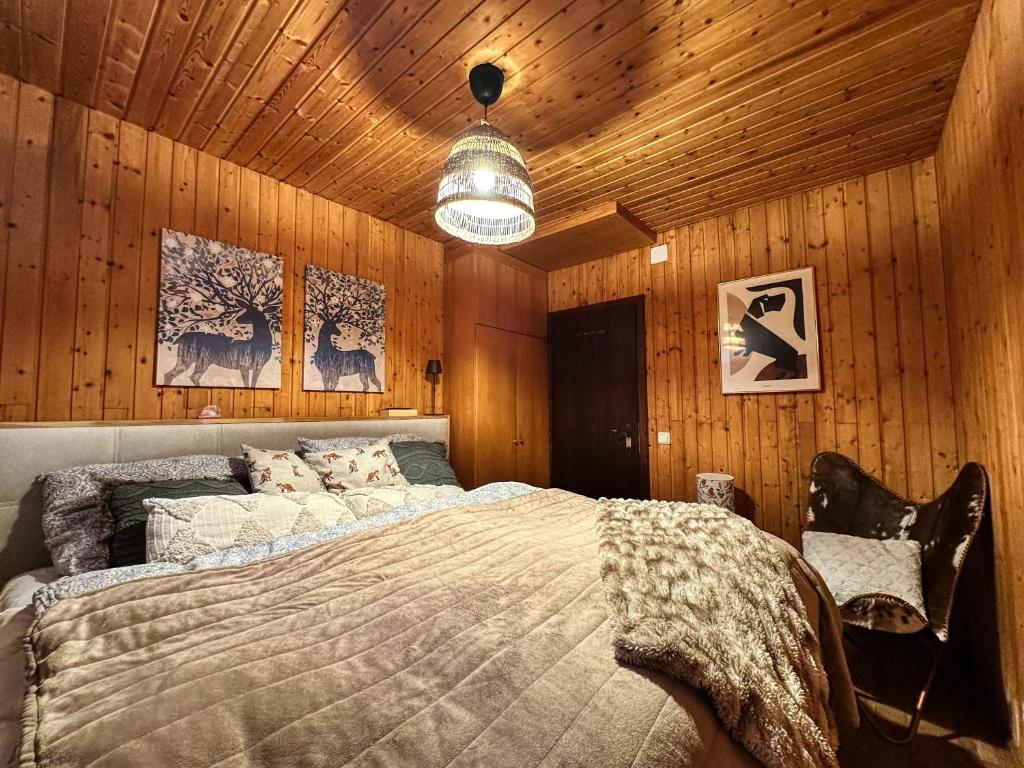 a bedroom with a large bed in a wooden wall at Sunny apartment Ula, close to Brunnachbahn in Sankt Oswald