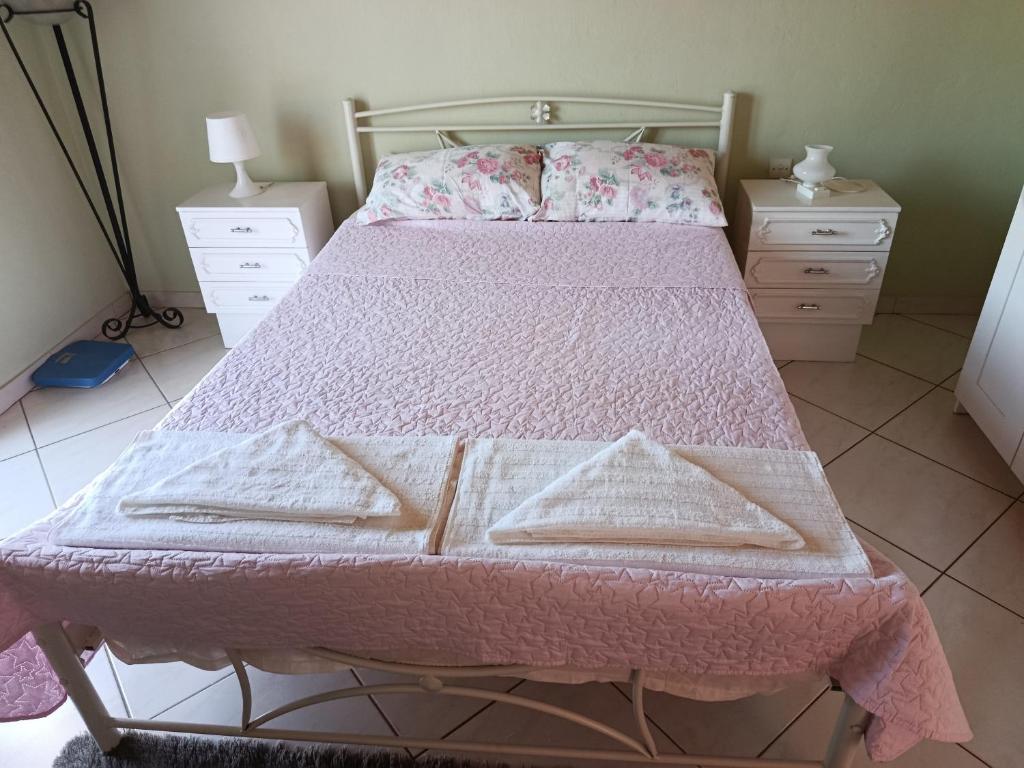 a bedroom with a bed with a pink bedspread at Όμορφο φυσικό περιβάλλον in Filippiada