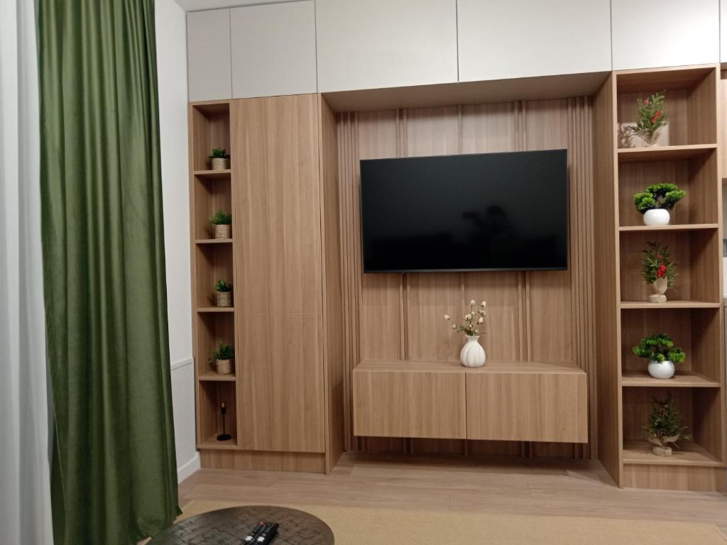 a living room with a television on a wooden wall at Zen aeroport confort in Sînnicoară