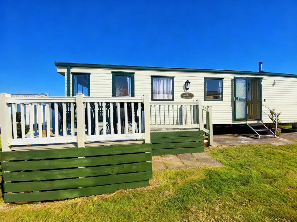 a mobile home with a green and white fence at The Wee Sprout in Stranraer