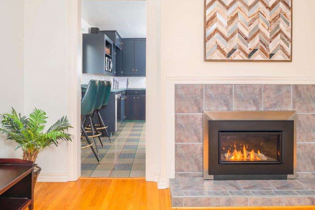 a living room with a fireplace and a kitchen at Private Riverside Retreat in Appleton