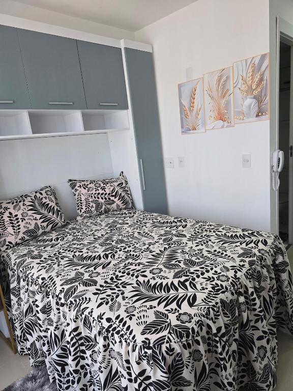 a bedroom with a bed with a black and white comforter at Full studio, TV, washing machine, microwave in Sao Paulo