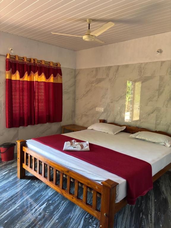 Un dormitorio con una cama grande con una cortina roja. en Shri Eshwari Homestay Murdeshwar, en Māvalli