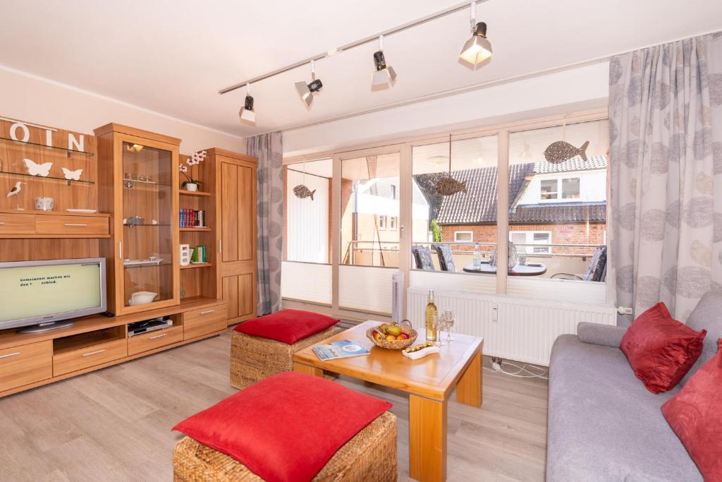 a living room with a couch and a tv at Ferienwohnung Nolte Grömitz in Grömitz