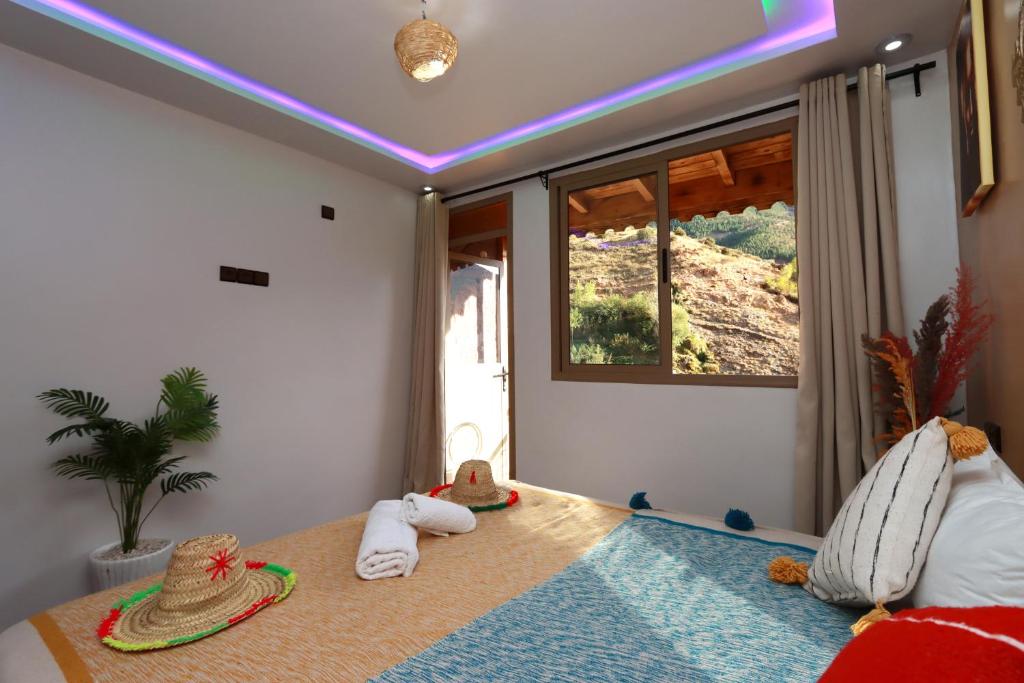 1 dormitorio con toallas y sombreros en una cama en Dar Tamatert, en Tamatert