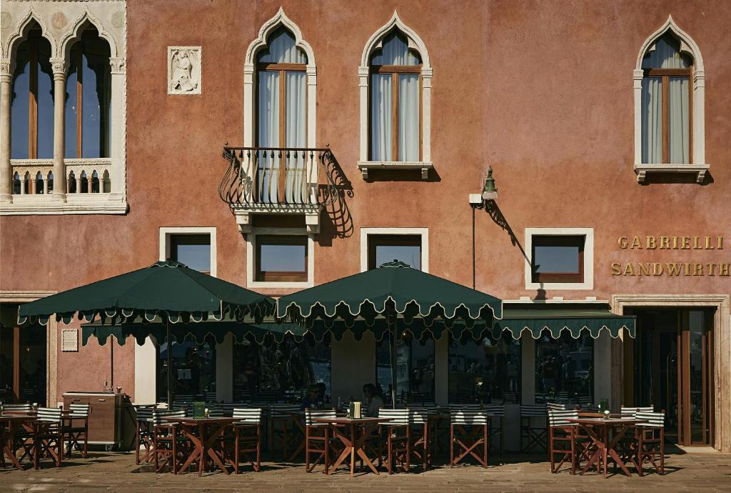 a restaurant with tables and chairs in front of a building at Hotel Gabrielli Venezia - Starhotels Collezione in Venice