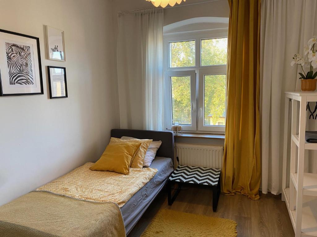a small bedroom with a bed and a window at Lemuria Hostel Szkolna centrum in Legnica