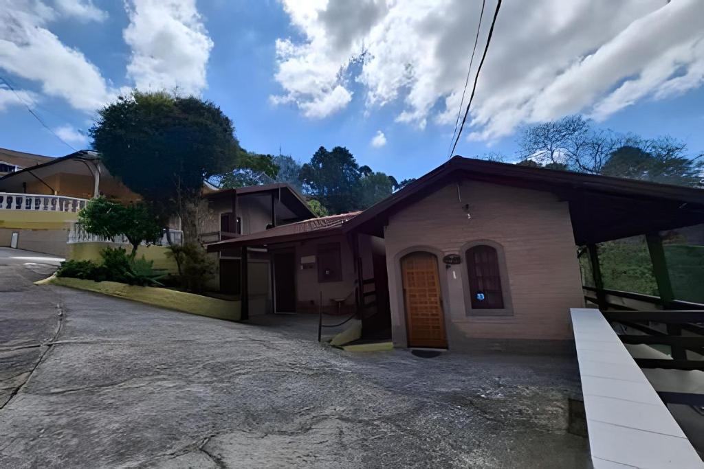a small house with a driveway in front of it at Chalés São Francisco I in Santo Antônio do Pinhal