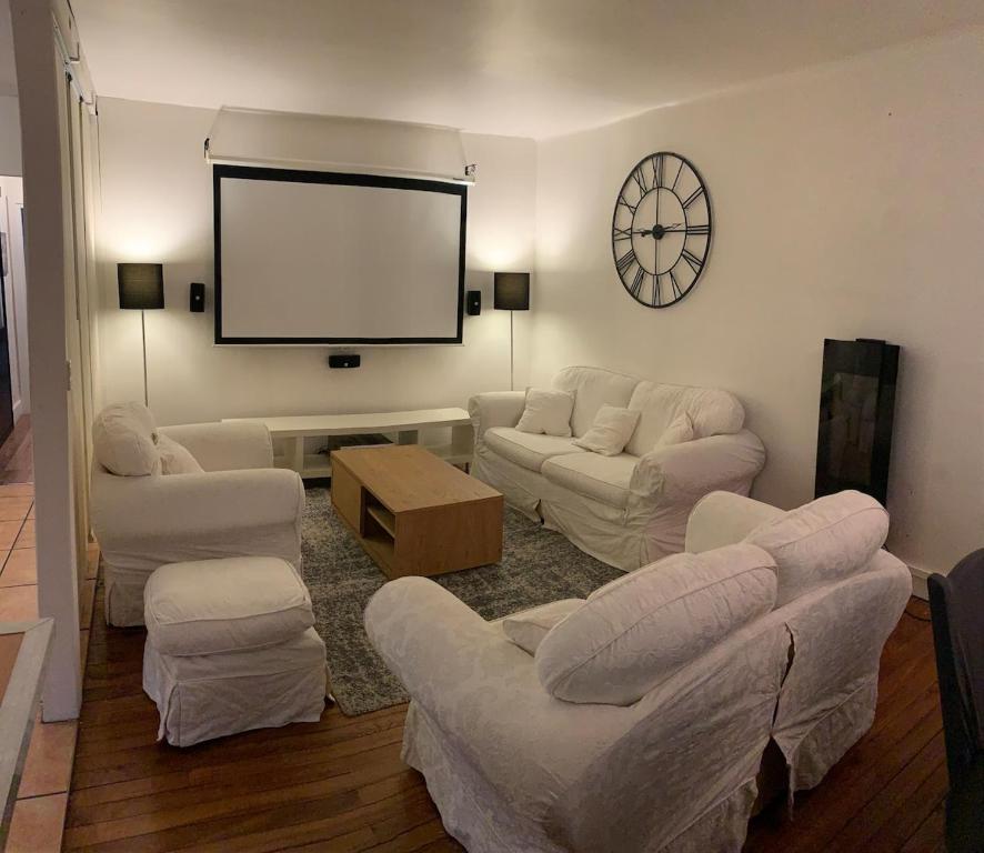 Una sala de estar con sofás y un televisor de pantalla plana. en Chez Hughes, en Montaigut-sur-Save