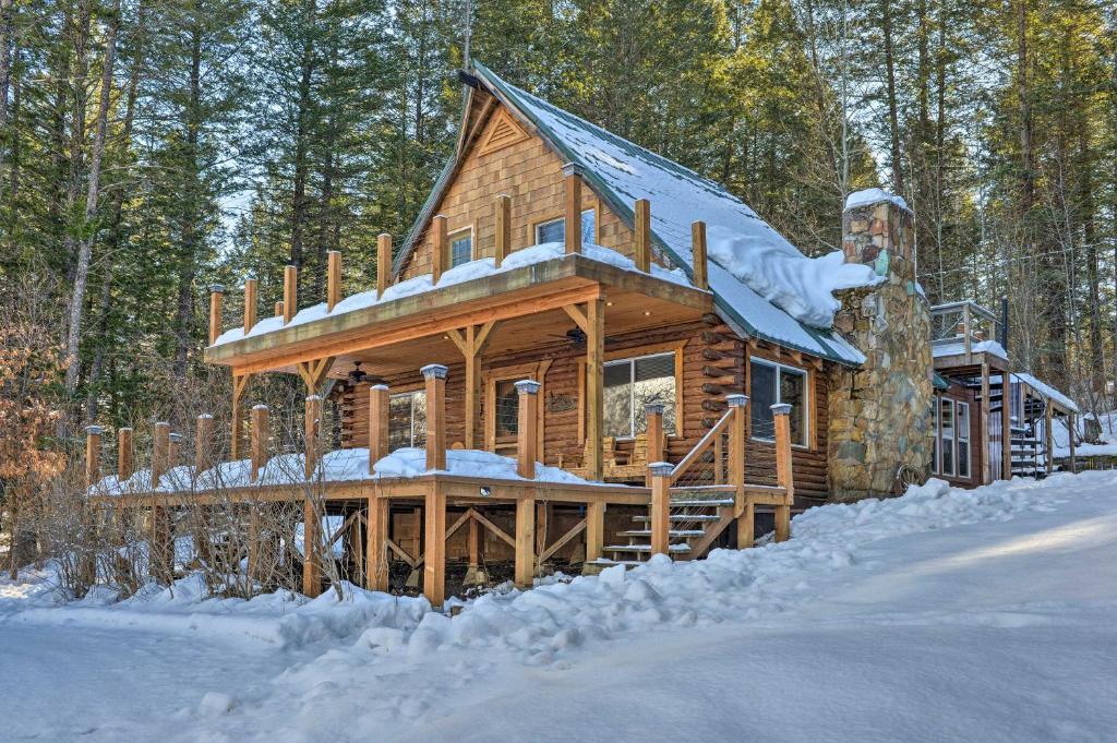 a log cabin in the woods in the snow at Alpine Adventures Cozy Log Cabin with Deck and Views! in Alpine