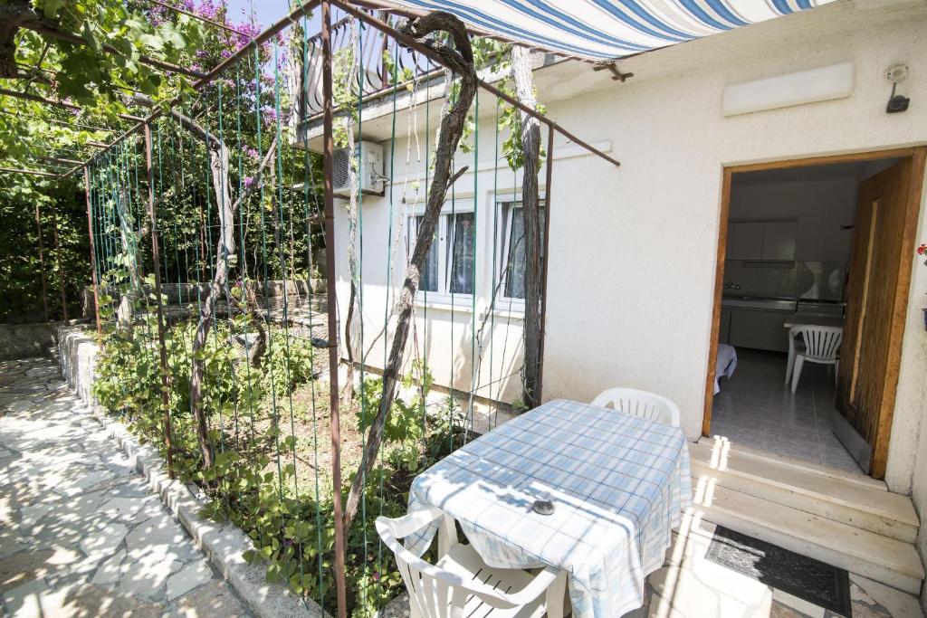 a patio with a table and chairs in front of a house at Apartament Skoko in Slatine