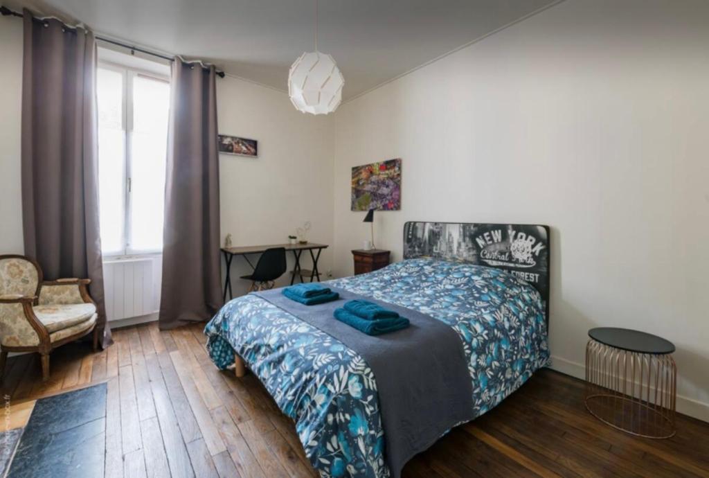 een slaapkamer met een bed, een stoel en een raam bij Apart city in Montargis