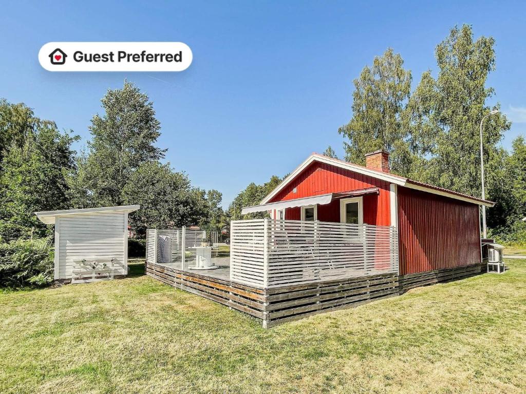 a small red and white shed on a grass field at 6 person holiday home in VIRSERUM in Virserum