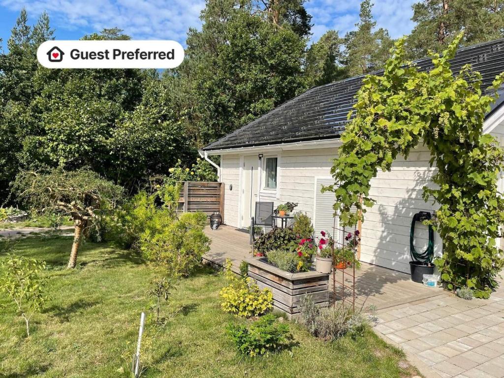 a small white house with a garden in front of it at Seaside Apartment Close to Borgholm in Borgholm