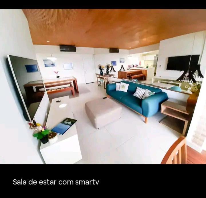 a living room with a blue couch and a table at Vista Serra e Mar in Bertioga