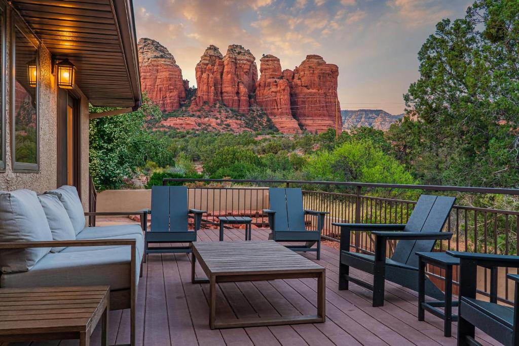 une terrasse avec des chaises et des tables offrant une vue sur un canyon dans l'établissement Sugarloaf House Private Trail Access Hot Tub Game Room OMG Red Rock Views, à Sedona