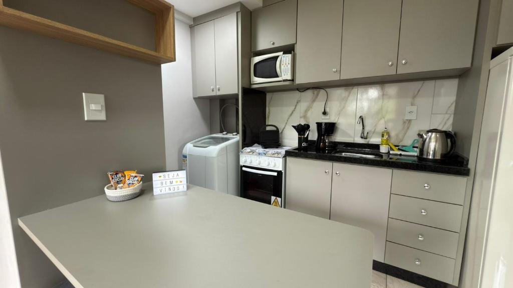 a kitchen with a white counter top and a refrigerator at Flat funcional e moderno em Uvaranas-com elevador in Ponta Grossa