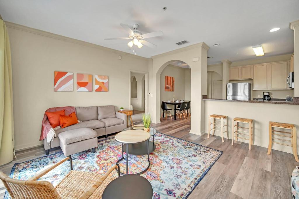 a living room with a couch and a kitchen at 2BR Condo with pool, near Disney! in Orlando