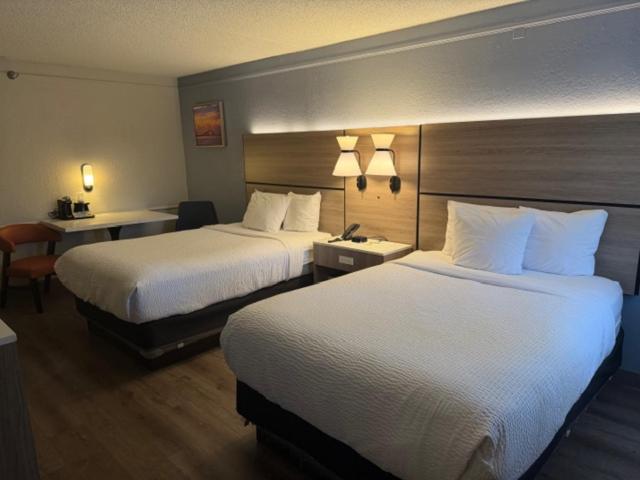 een hotelkamer met twee bedden en een bureau bij La Quinta by Wyndham Pinellas Park St Peterburg Clearwater in Pinellas Park