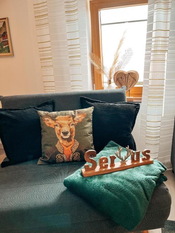 ヴィヒタッハにあるApartment Viechtachの犬が描かれた枕が置かれた青いソファ