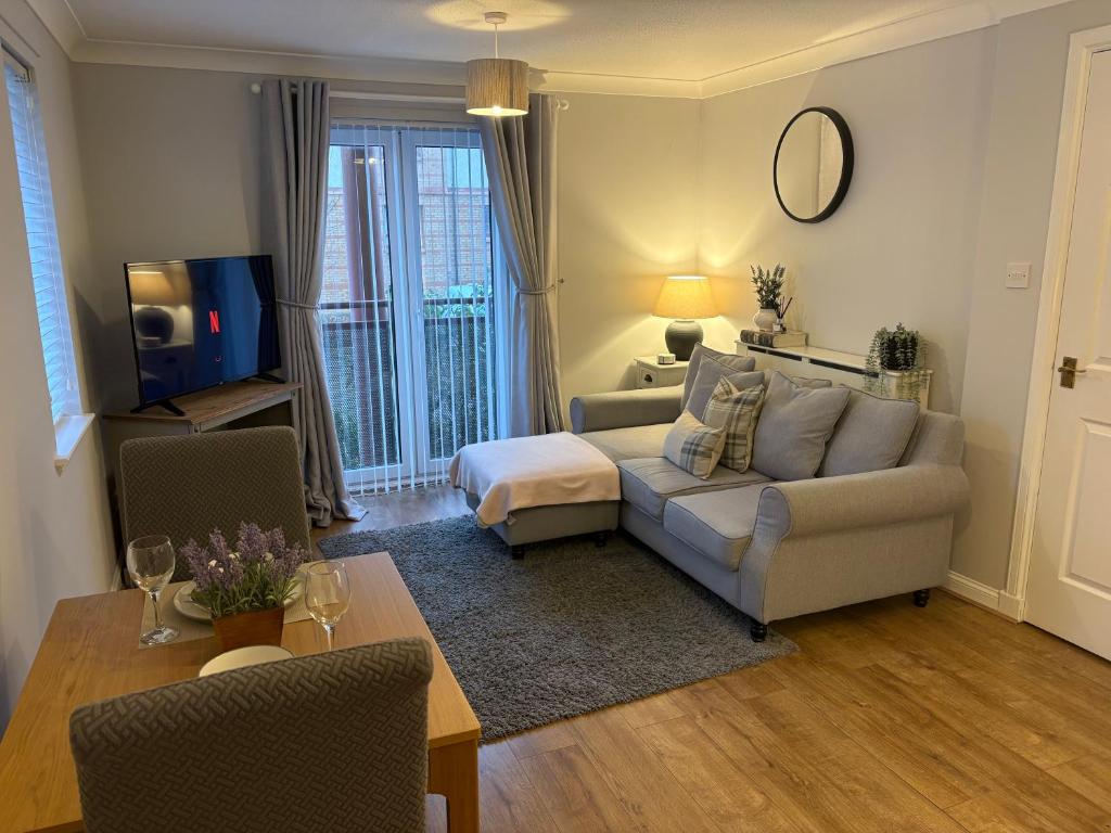 a living room with a couch and a tv in it at Kinfirth Apartment in Ayr