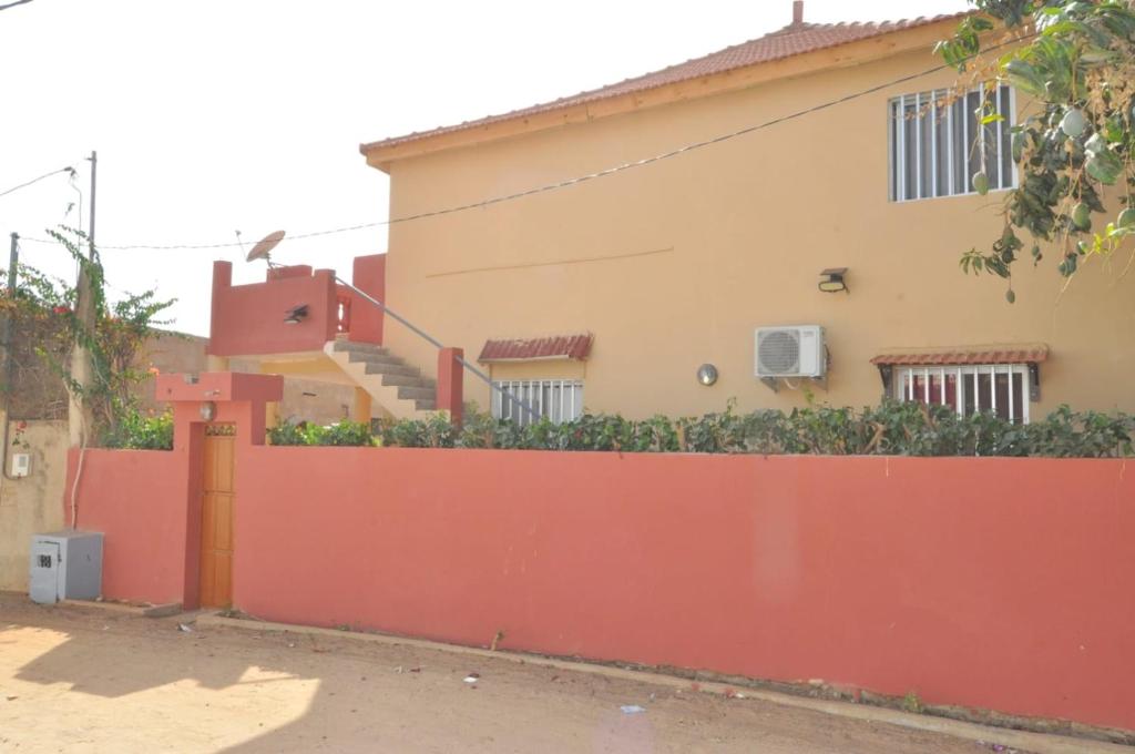 a house with a orange fence and stairs at maison rio la rufisquoise in Saly Portudal