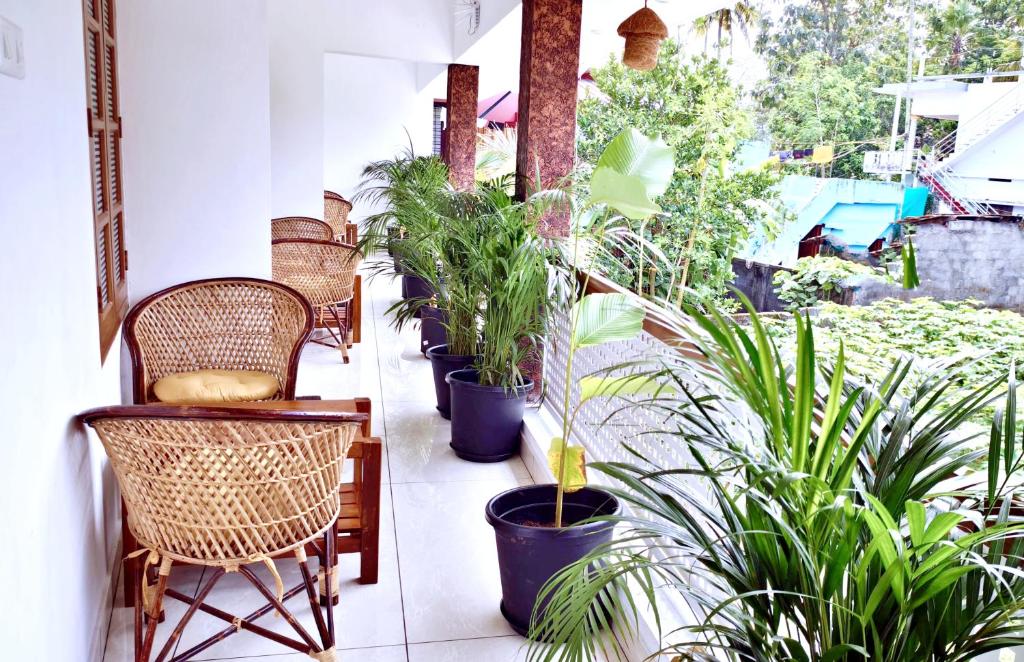 a balcony with chairs and potted plants on it at Gypsy Walker Plus in Varkala