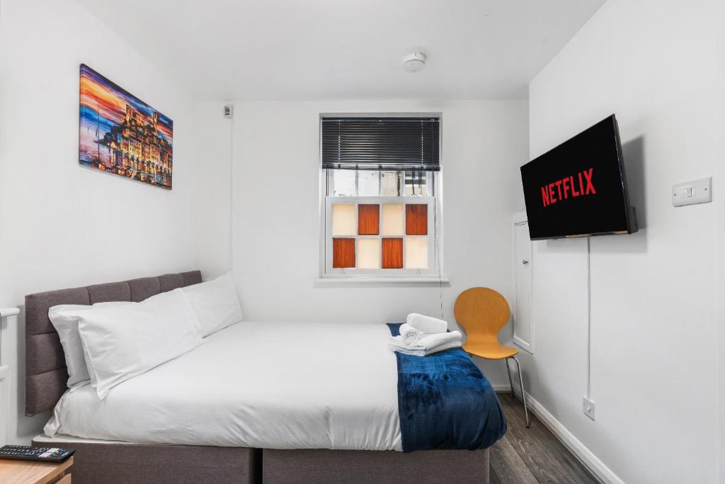 a small bedroom with a bed and a window at Guest and the City - Group Bookings in Brighton & Hove