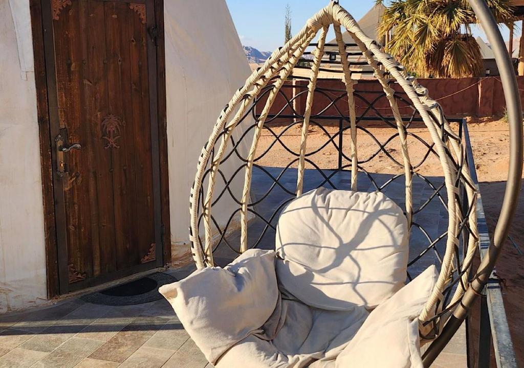 a bed in a rope swing next to a door at hamza in Wadi Rum