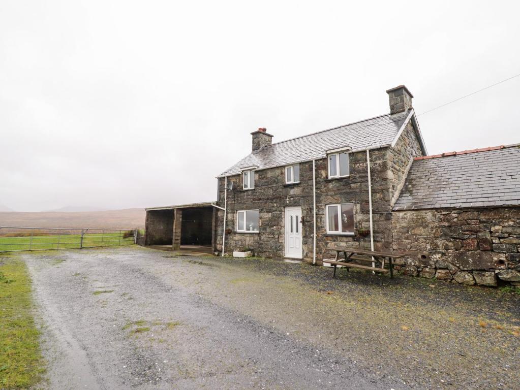 an old stone house on the side of a dirt road at Bryn Re in Trawsfynydd