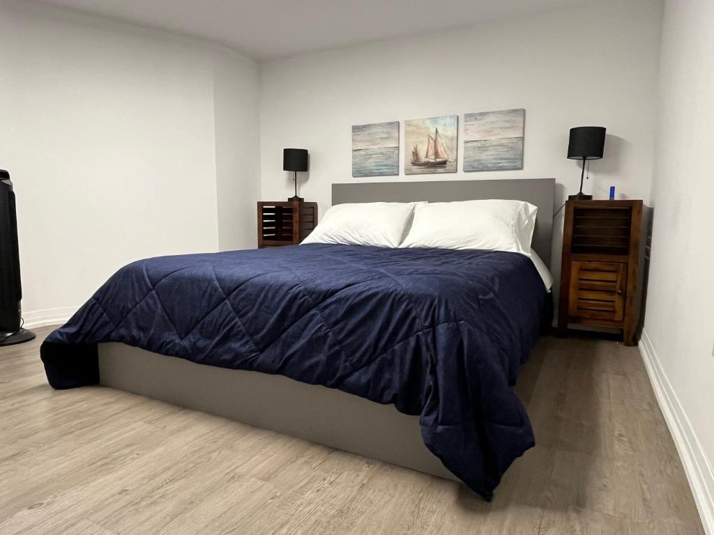 Un dormitorio con una cama grande con una manta azul. en Merritt Place Niagara, en St. Catharines