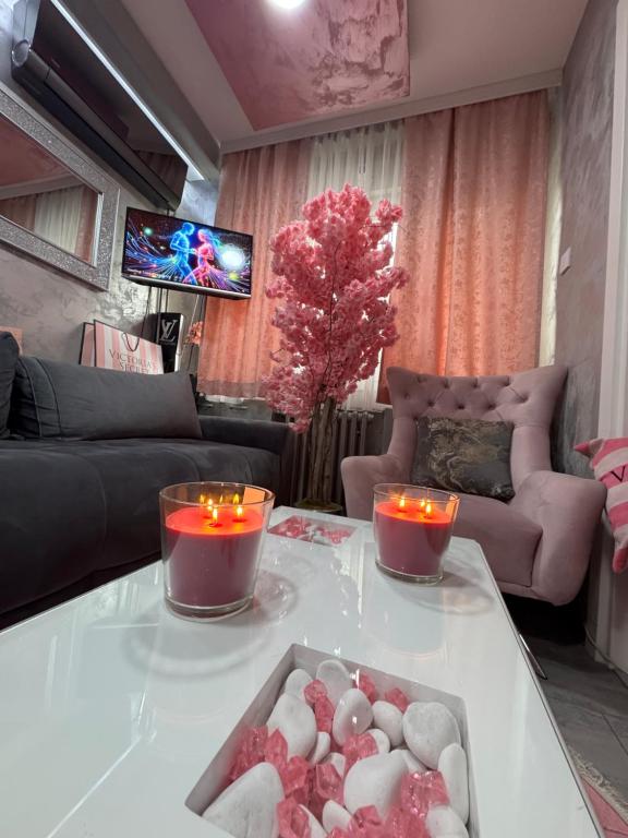 a living room with candles on a white table at Analadyboss in Leskovac