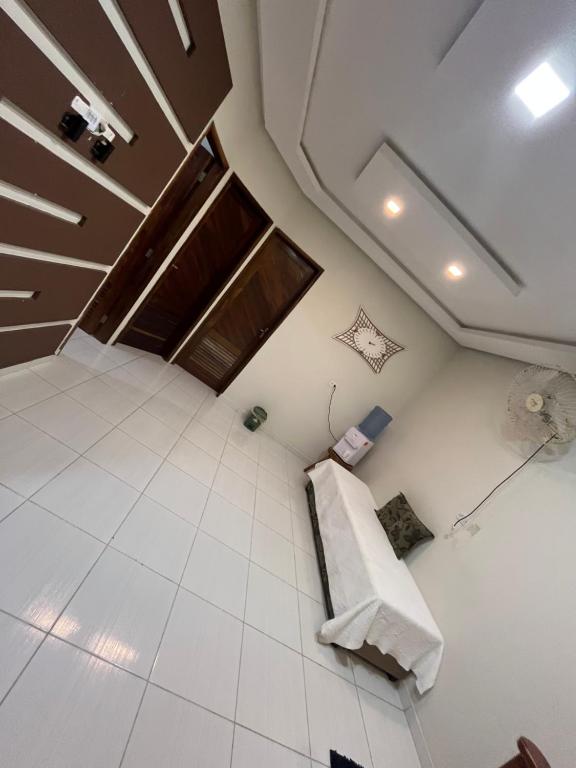 een lege kamer met witte tegelvloeren en een plafond bij Residência 02 in Japaratinga